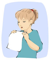 girl blowing on paper