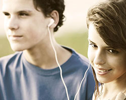 Teenagers sharing music through earbuds