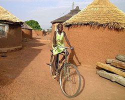 Child bicycling through village