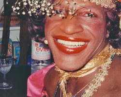 A close up image of Marsha P. Johnson smiling and wearing a flower crown