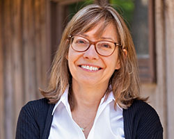 A picture of Alice Dreger, a woman wearing glasses and smiling.