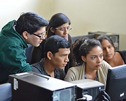 Several students working together around a computer