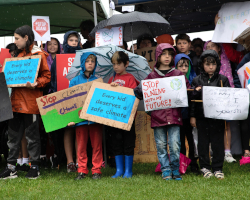 young children protesting for climate change in the rain