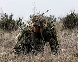 Un soldat dans un costume de ghillie