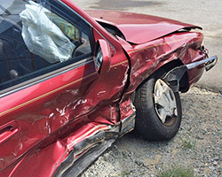 A car that has been totaled from a car crash, with a crushed right side of the body.