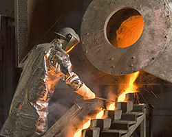 A worker pouring metal into molds