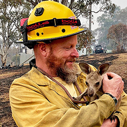 Fire fighter holding a baby kangaroo