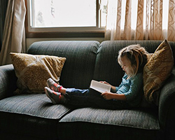 Young girl reading on the couch