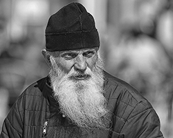 A black and white picture of an old man with a long beard