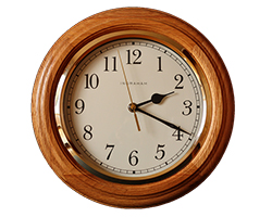 A wall clock in a wooden frame