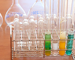chemistry lab equipment, including test tubes with different colored solutions inside