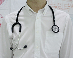 A stethoscope hanging around a male doctor's neck