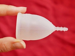 Fingers holding a menstrual cup