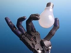 A robot hand holding a lightbulb