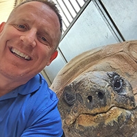 Dr. Gary West with Ali the Aldabra tortoise.