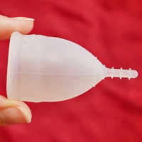 Fingers holding a menstrual cup