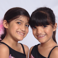 A picture of two young twin girls smiling.