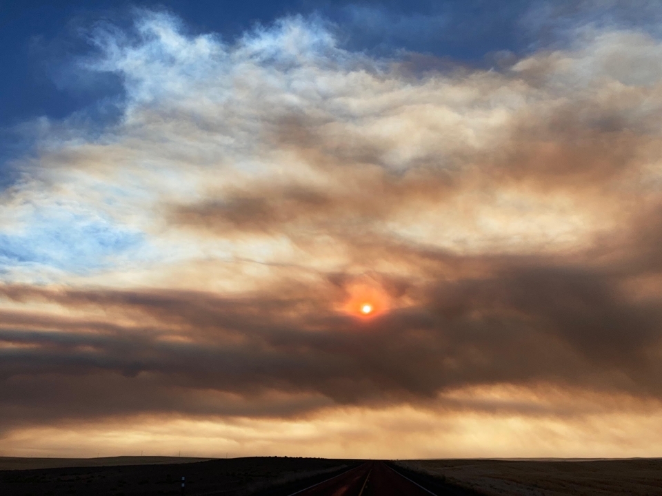 Une image du soleil enveloppé de fumée et de nuages.