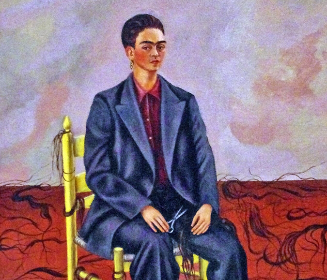 A self portrait of Frida Kahlo sitting in a chair, wearing a suit with cut hair surrounding her on the floor.