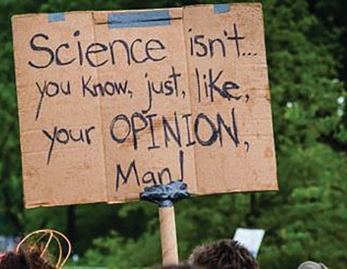 Un letrero en una protesta que dice "La ciencia no es, ya sabes, solo como tu opinión, hombre".