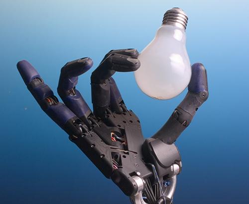 A robot hand holding a light bulb